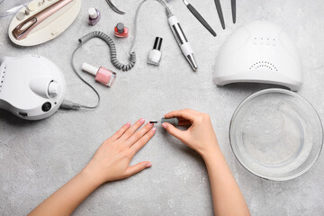 Woman applying nail polish on light table