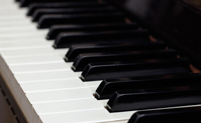 Classic wooden piano with white and black keys. Music education.
