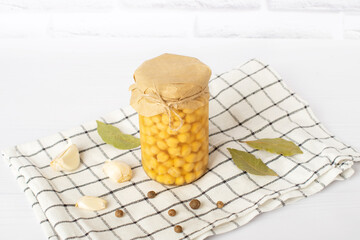 Raw dry chickpeas in a glass jar. canned jar of chickpeas, on a white table