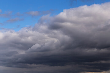 Epic Dramatic storm dark grey cumulus rain clouds against blue sky background texture	
