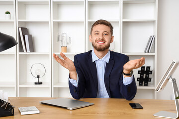 Handsome young businessman video chatting in office