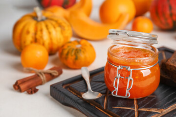 Jar of sweet pumpkin jam on white background