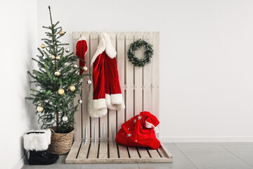 Obraz premium Beautiful Christmas tree and Santa Claus costume in light hallway