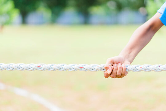 kid children hands holding rope playing tug of war during joint outdoors games on sunny day.Game, challenge, unity, responsibility, cooperation, ready, help, Outdoor activity game.tug of war. teamwork