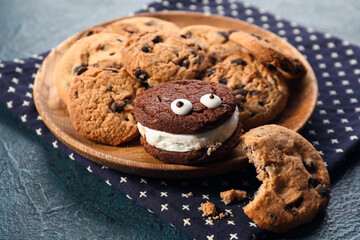 Plate with tasty cookies for Halloween on dark background