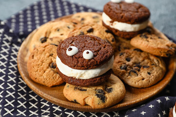 Plate with tasty cookies for Halloween on dark background