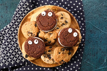 Plate with tasty cookies for Halloween on dark background
