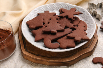 Plate with tasty chocolate Christmas cookies on light background