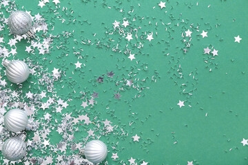 Beautiful confetti and Christmas balls on green background