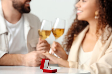 Box with engagement ring on table of young couple. Marriage proposal concept