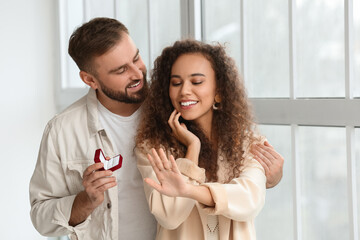 Young man proposing to his girlfriend at home