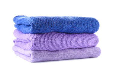 Stack of soft modern sweaters on white background