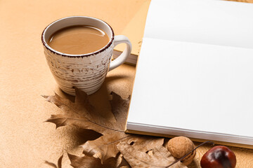 Fototapeta na wymiar Blank book, cup of tasty coffee and autumn decor on beige background