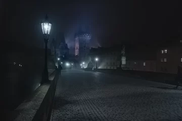 Papier Peint photo Pont Charles Street lamps and light from them on the old stone Charles Bridge in the night fog and silhouettes of figures