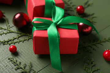Composition with gift boxes, thuja branches and decorations on color wooden background, closeup