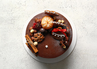 Stand with tasty Christmas chocolate cake on light background
