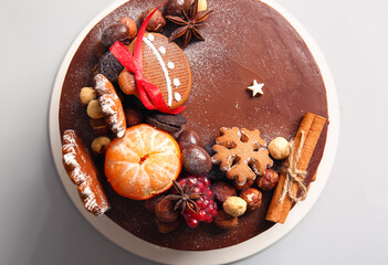 Stand with tasty Christmas chocolate cake on light background