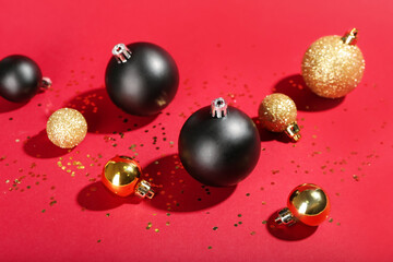 Different bright Christmas balls with confetti on color background