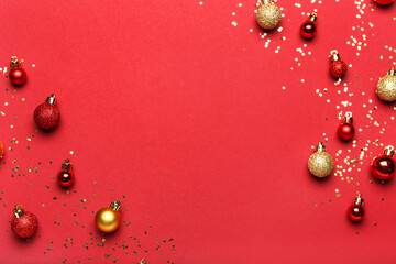 Different bright Christmas balls with confetti on color background