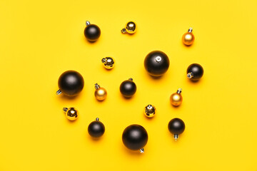 Different bright Christmas balls on yellow background