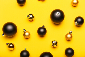 Different bright Christmas balls on yellow background