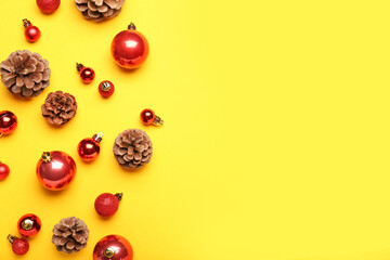 Bright Christmas balls with cones on yellow background