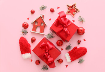 Composition with Christmas gift boxes, balls, fir branches and model of house on pink background