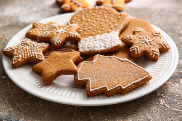 Plate with sweet Christmas gingerbread cookies on grey background