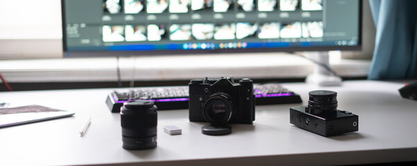 photo studio, photographer workplace table with retro style camera and desktop editing computer