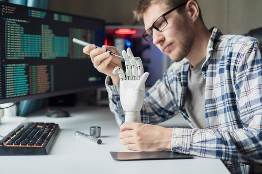 male engineer working on the development of robotic arm or hand, new modern technology concept