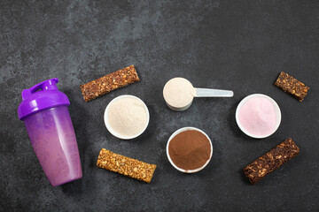 Shaker, Measuring scoop of protein powder and energetic musli bars on dark background.