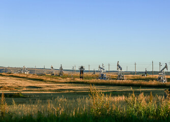 Oil production, field, sky. Oil pumps. Beautiful landscape. Blurred background.