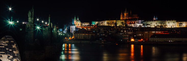street lamps and old tower on Charles Bridge in the city of Prague at night 2021
