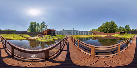 full seamless spherical hdr 360 panorama on wooden pedestrian bridge over lake near vacation home...
