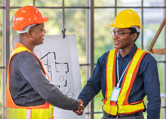 African American engineer and architect handshaking for agreement in partnership project for construction and urban real estate development concept