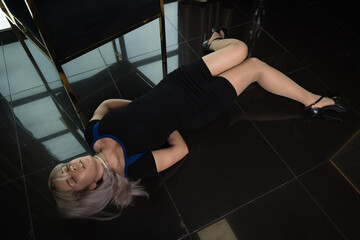 Crime scene simulation: dead girl with hands tied lying on the floor. She was strangled with a...