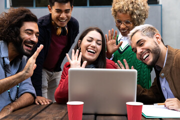 Smiling multiracial group of friends on a video call waving hand saying hello to friend © Daniel