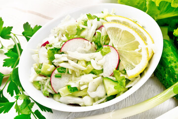 Salad of cabbage with radish in plate on white board