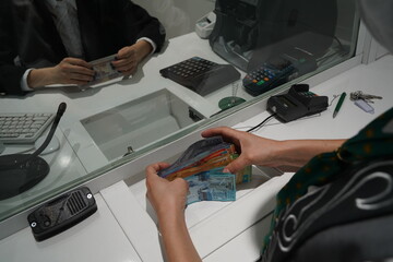 Almaty, Kazakhstan - 11.16.2021 : Counting and transfer of banknotes through the bank's cash desk