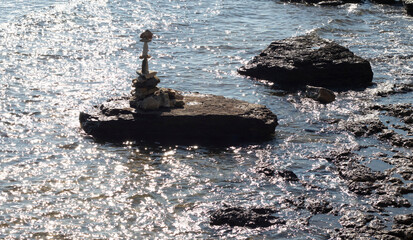 pyramid of stones in the sea sparkling in the sun