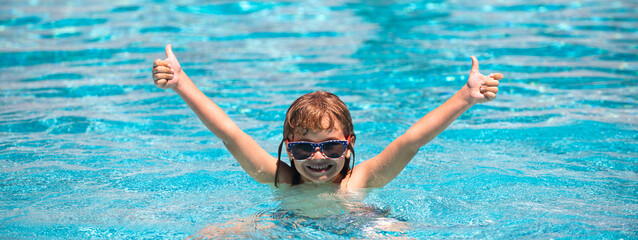 Child raised hands in summer swimming pool. Active kids healthy lifestyle, water sport activity and swimming lessons on summer vacation with child. Banner, copy space.