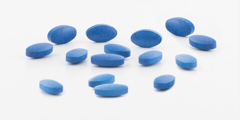 Blue pills, medicine isolated on white background with blue frame