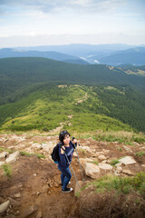 Fototapeta na wymiar Girl Descend Down a Large Green Mountain Range