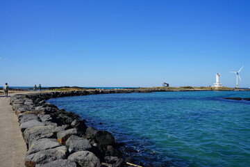 Fototapeta na wymiar a wonderful seascape with lighthouse and wind power plant