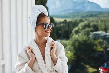 Portrait of gorgeous woman in a bathrobe in the morning on the balcony admiring nature Mountain View