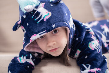 Portrait of a little girl in pajamas with a hood.