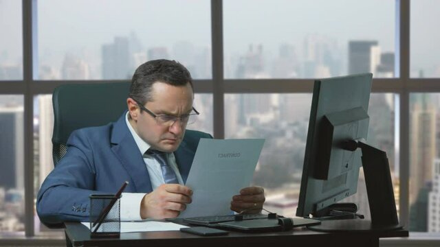 Man with suit and tie breaks the paper, frustration, cancel agreement, city view