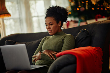 African woman using laptop at home