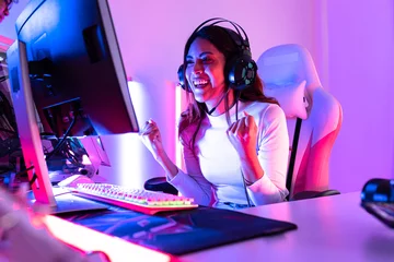 Fotobehang Gaming young  playing game online at home. Gamer  controlling joystick for video game. Teenage girls leisure game in neon light room at home.  © anon