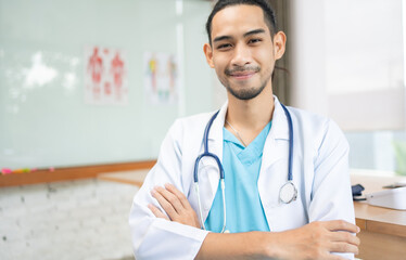 Confident young Asia male doctor in white medical uniform with stethoscope looking at camera and smiling while video conference call with patient in health hospital.